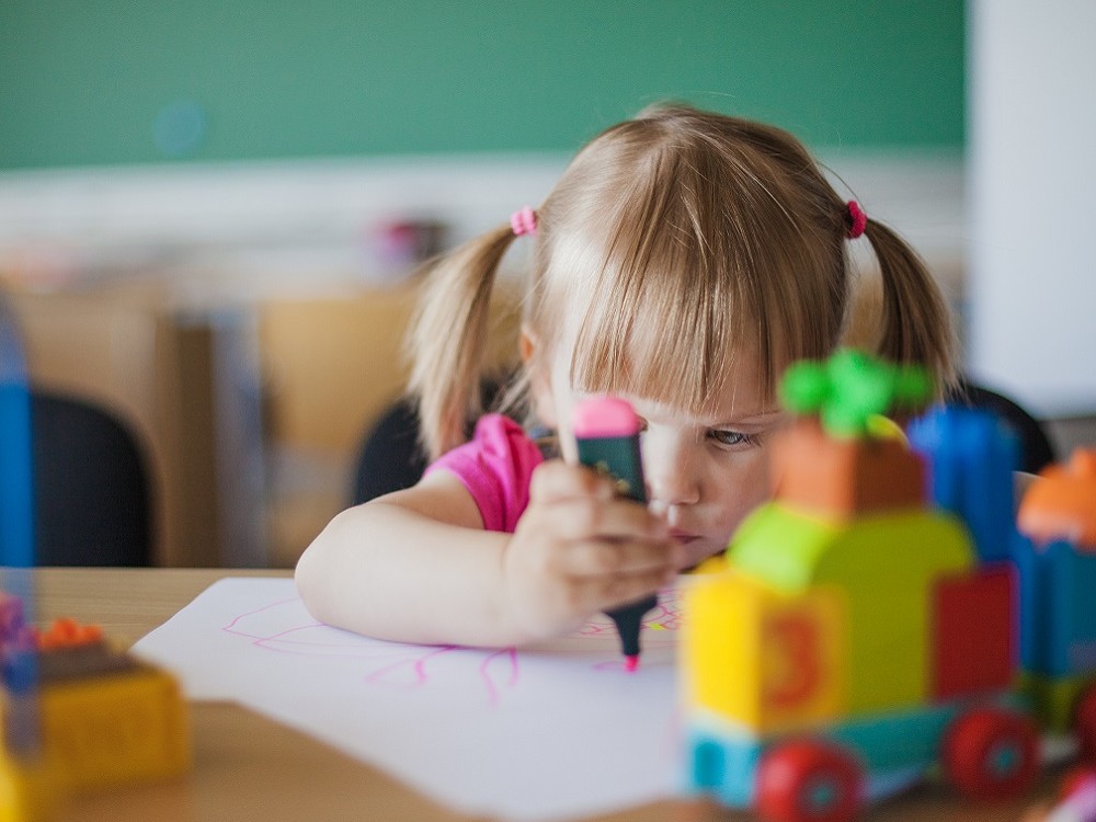 Niña dibujando en el cole